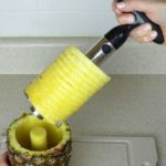 Pulling the OXO Good Grips Pineapple Corer out with pineapple rings attached