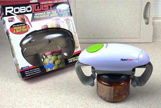 RoboTwist Automatic Jar Opener ready to open a jar, pictured with RoboTwist packaging.
